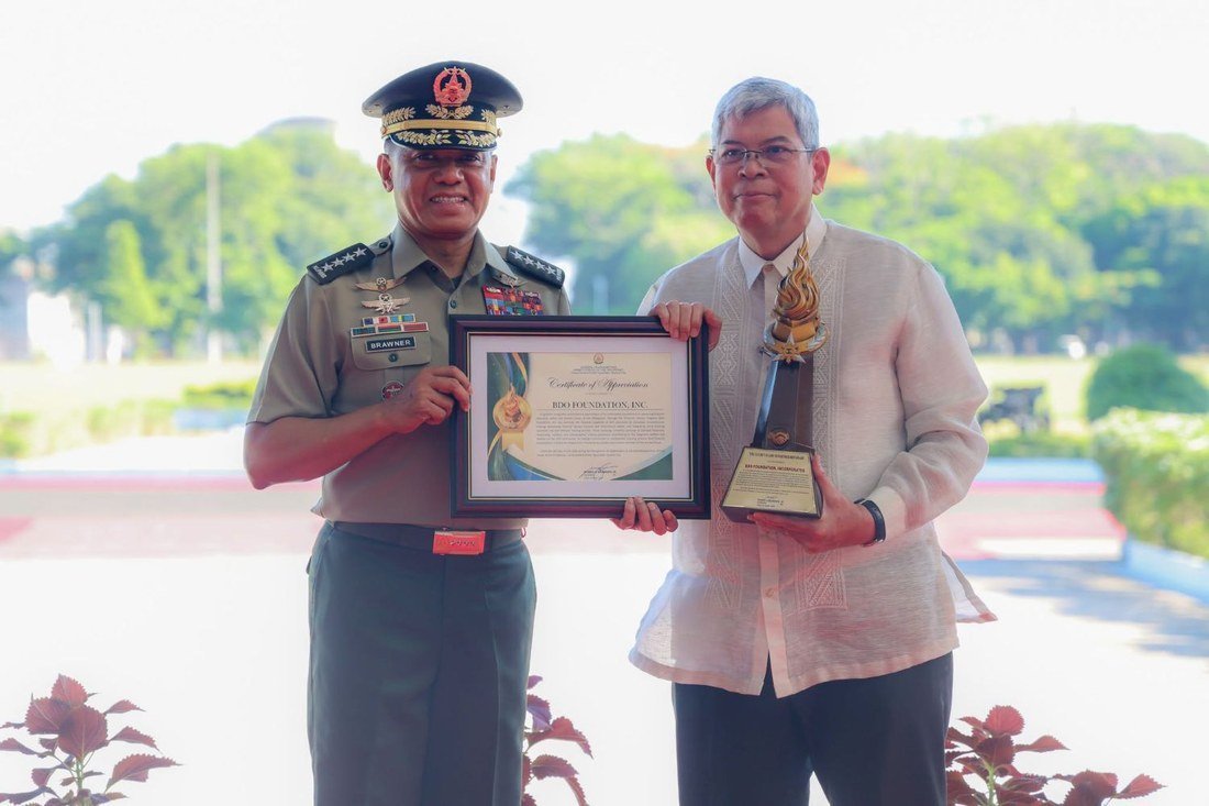 Gen. Romeo Brawner Jr. presenting the Golden Flame of Partnership Award to BDO Foundation president Mario A. Deriquito